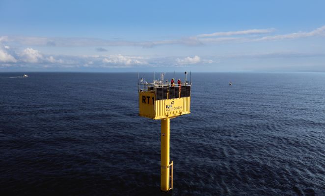 Tall yellow offshore wind test facility surrounded by the North Sea