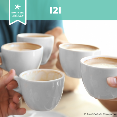 Closeup of hands holding five cups of coffee.