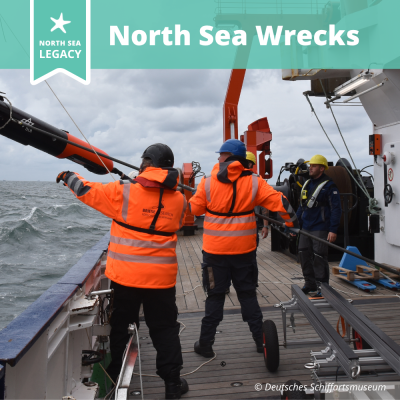 People on the deck of a ship, handling equipment in rough weather