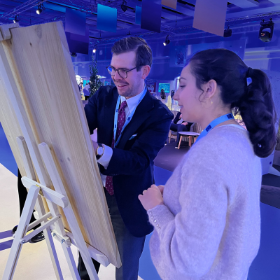 Two people standing by a pin board
