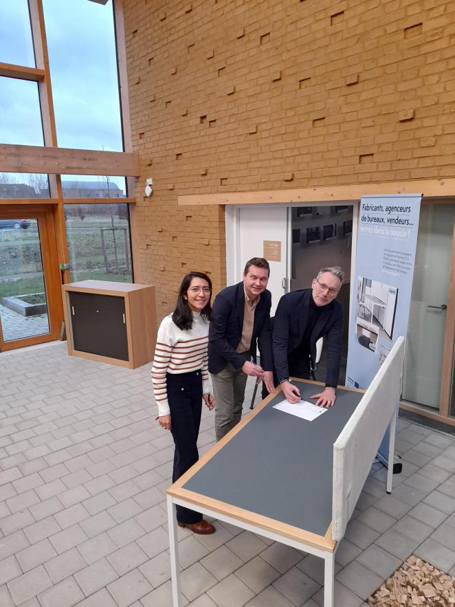 Three people from France pilot standing together at a table