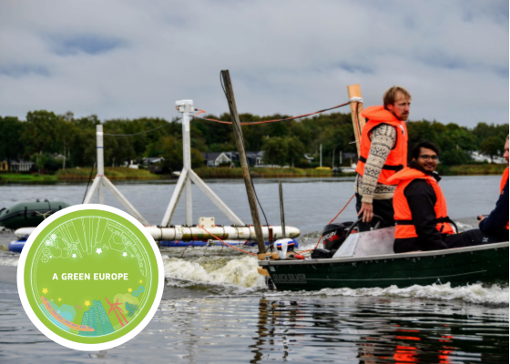 A group of people wearing safety vests, in a boat dragging scientific equipment. across a lake.