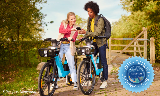 Two people with bikes checking an app in a green area in sunny weather.