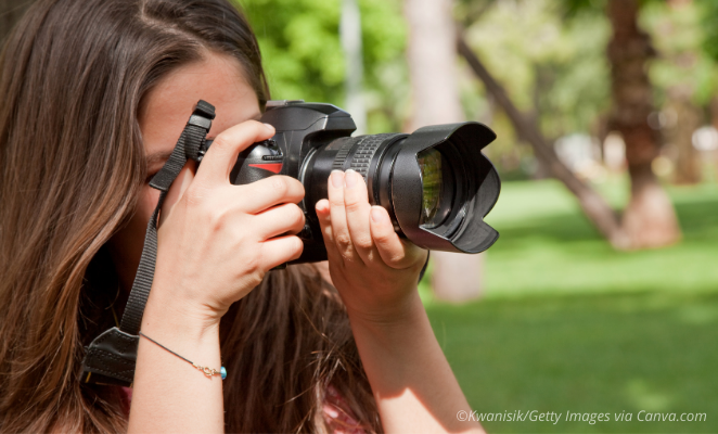 Young lady taking photos outdoors.