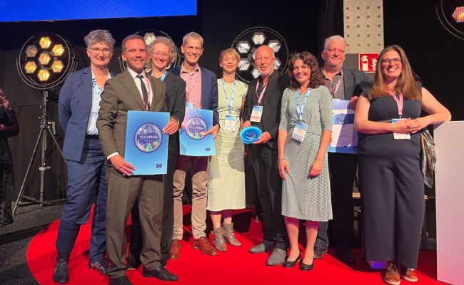 A group of smiling people on a stage. 