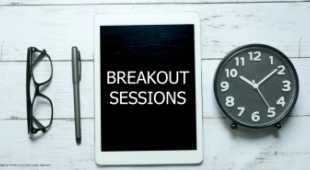 A pair of glasses, a pen, a clock and a sign saying breakout session