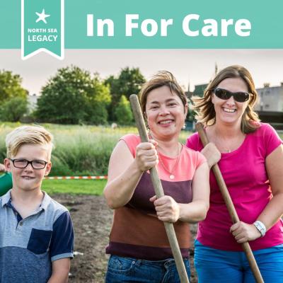 A young boy and two smiling ladies holding garden tools in a green urban area. 