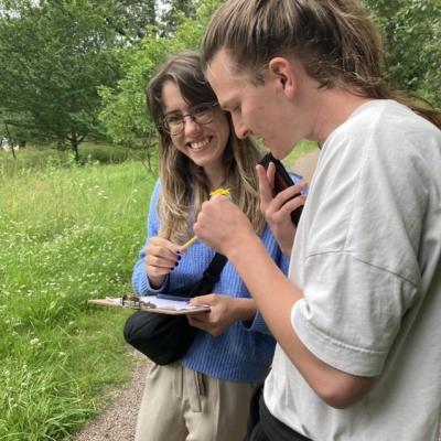 Two people examining their findings from the meadow